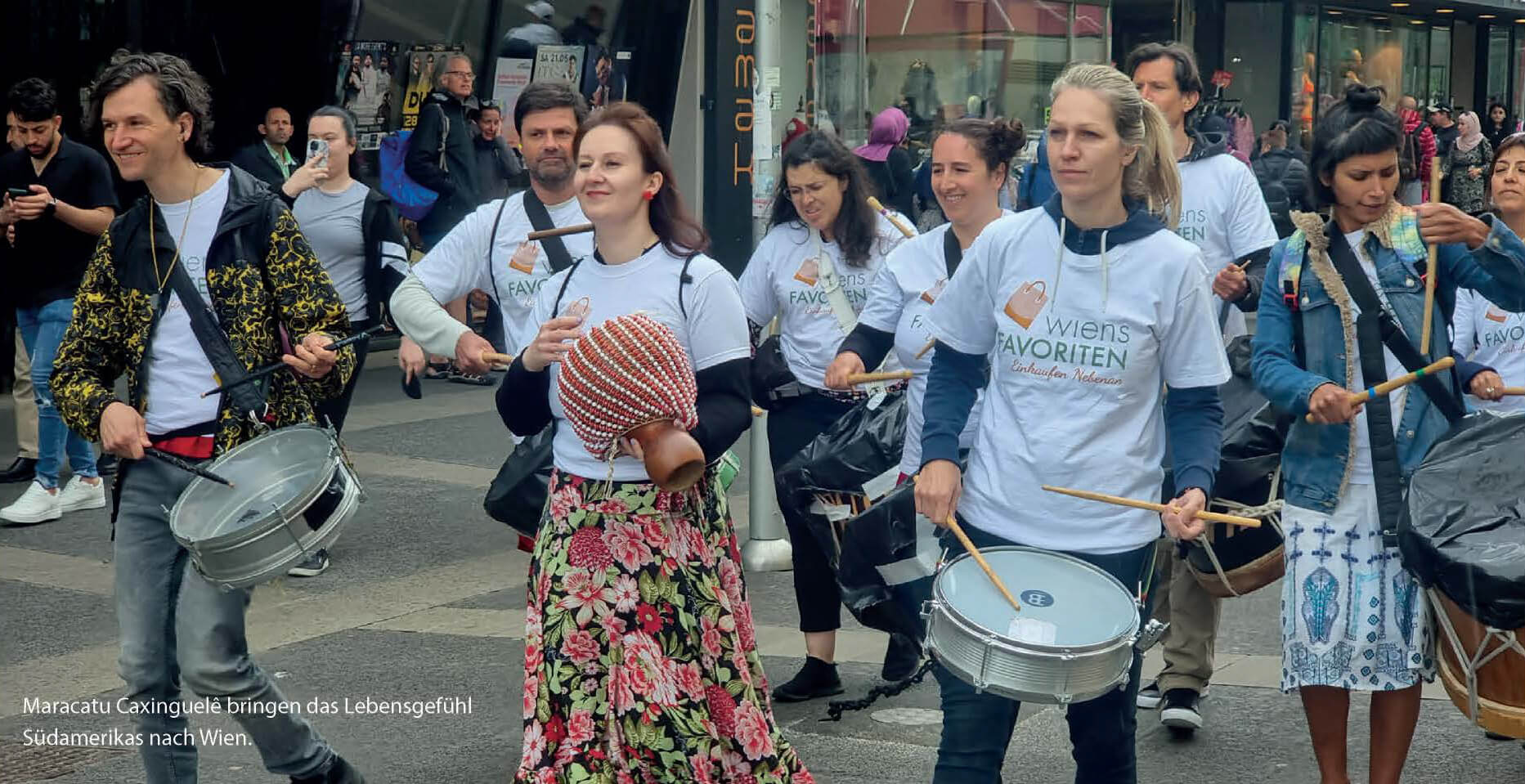 Eine Gruppe Trommler mit Wiens Favoriten T-Shirts in der Favoritenstrasse